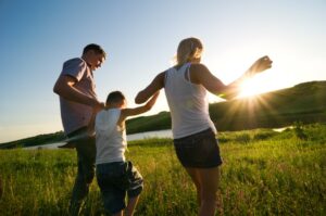 a family walking through a grass field with Whole Life Insurance in Murrieta, Temecula, Lake Elsinore, Wildomar, Winchester, CA and Nearby Cities