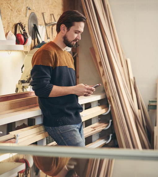 Man in Shop on his phone reviewing his Business Insurance in Lake Elsinore